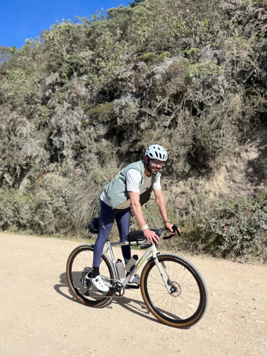Ciclista con chaleco rodando por un camino de grava en Guasca – Guatavita