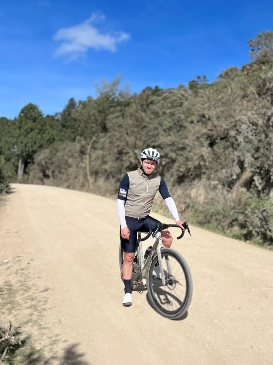 Ciclista de gravel sobre un camino destapado bajo cielo azul, Pantano de Martus