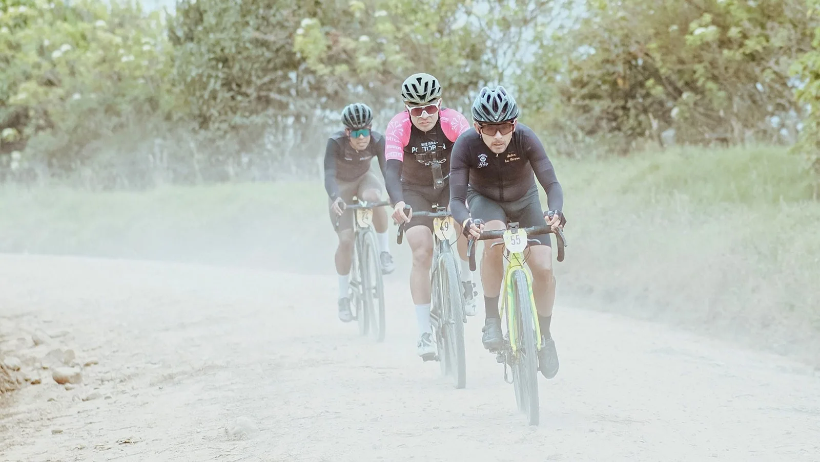 Ciclistas rodando en bicicleta de gravel por un camino rural de tierra en la Sabana de Bogotá, con Rural Cycle